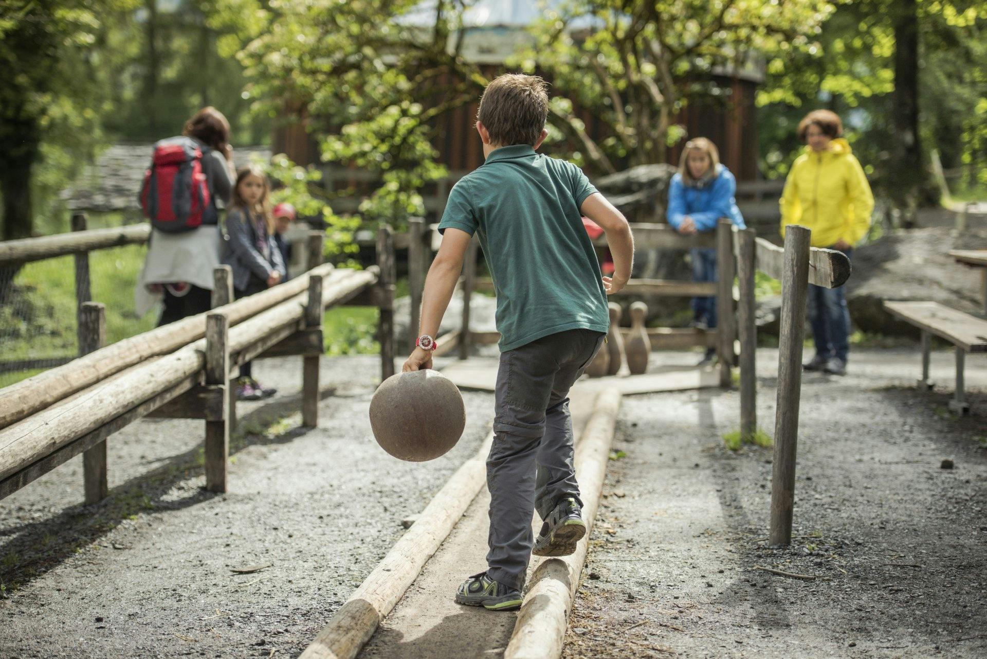 Kinder spielen auf der Kegelbahn im Freilichtmuseum Ballenberg.