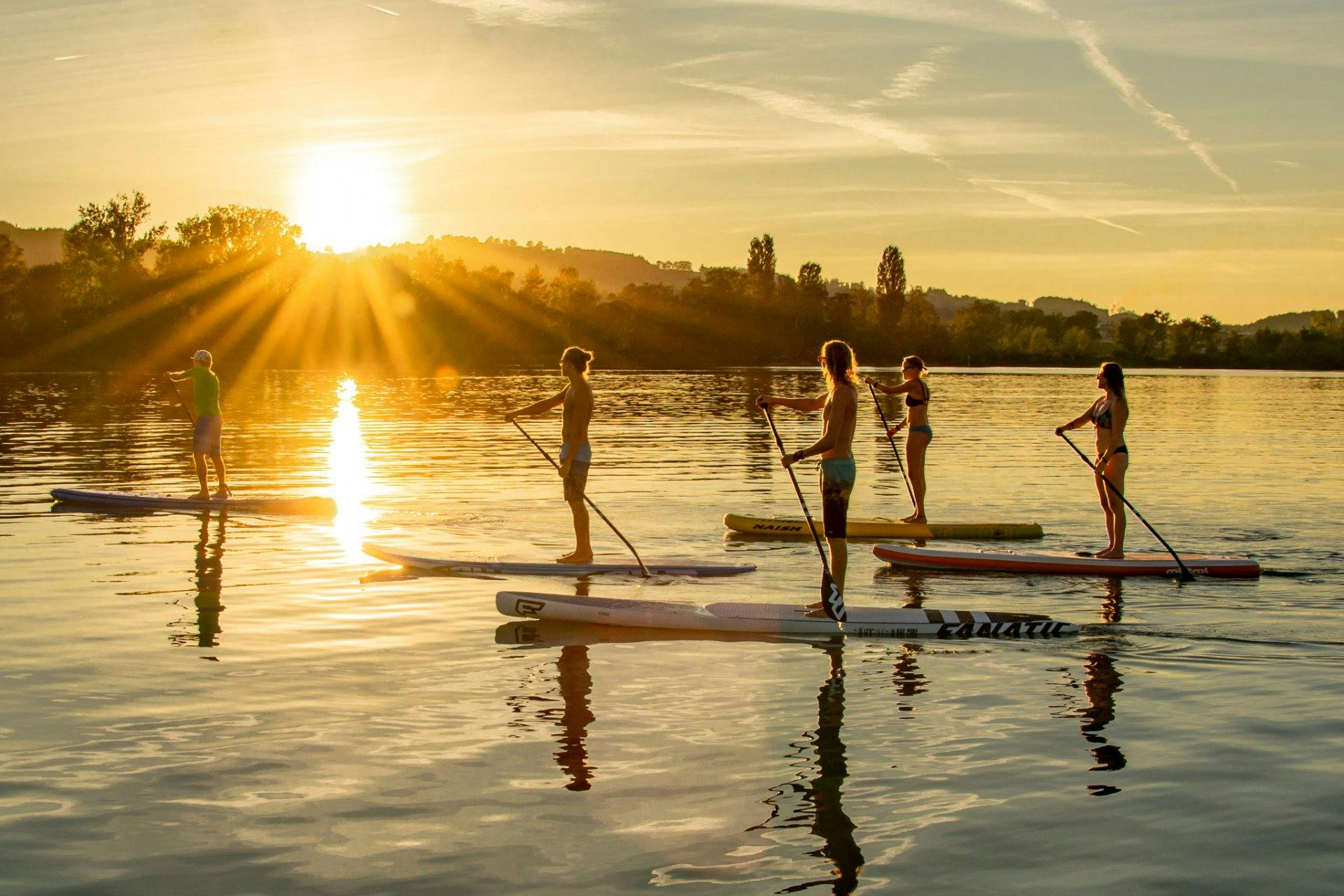 Auf dem Sempachersee dem Sonnenuntergang auf einem SUP entgegen paddeln.