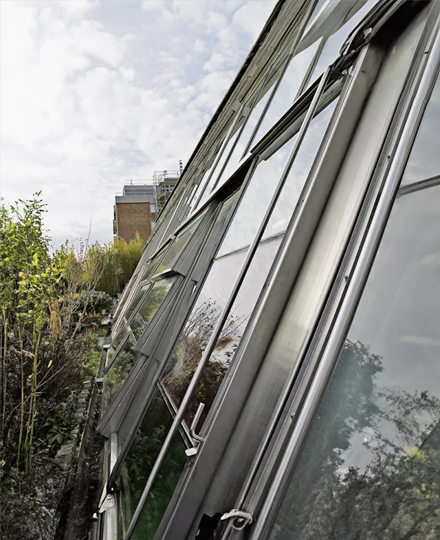 Die schräge Glasfront speichert jeden Sonnenstrahl und macht die Wintergärten zu warmen Oasen.