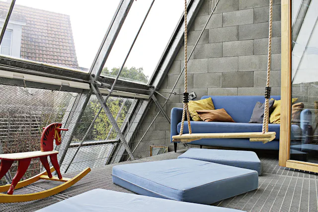 Wild und wunderbar: Vom Kinderzimmer im mittleren Stock aus geht es direkt auf das mit Schaukel bestückte Spielparadies mit Glasfront.