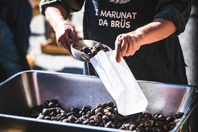 Des «brasché» tout juste sortis des braises: pendant la Semaine de la châtaigne, un Marunat de Brusio remplit un sachet de marrons chauds.