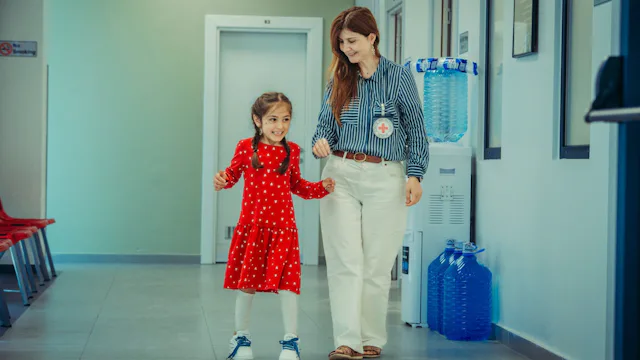 Erbil, Irak. Im IKRK-Rehabilitationszentrum hilft eine Mitarbeiterin einem kleinen Mädchen mit einer Prothese beim Gehen.