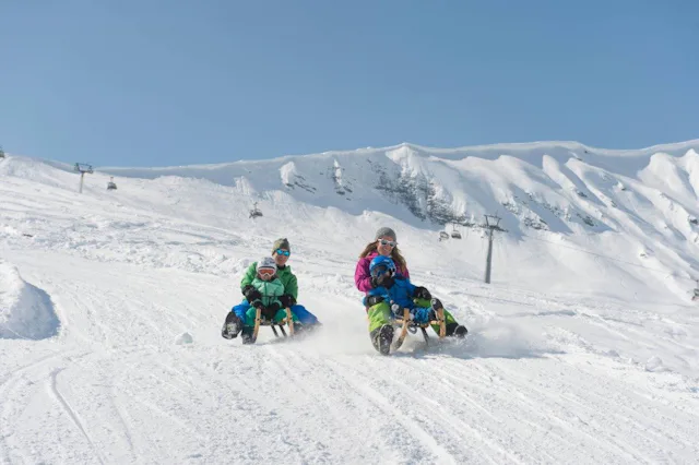 Dans la poudreuse, sur la Tschentenalp, les adultes profitent autant des plaisirs hivernaux que les enfants.